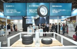 A UR30 collaborative robot arm lifting up a tire at iREX 2023 in Tokyo.